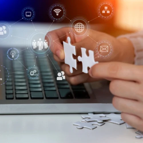 Hands,Of,Businesswoman,Connecting,Jigsaw,Puzzle,With,Laptop,And,Connection